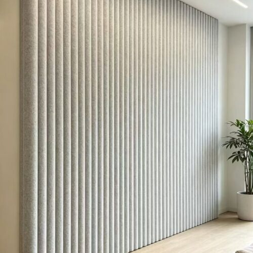 Indoor full‑wall installation of light grey vertical ribbed 3D acoustic panels Indoor full‑wall installation of light grey vertical ribbed 3D acoustic panels
