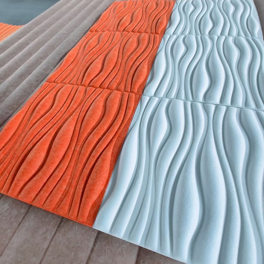 Orange and light blue 3D acoustic panels with wavy thermoformed patterns made of PET polyester fiber.